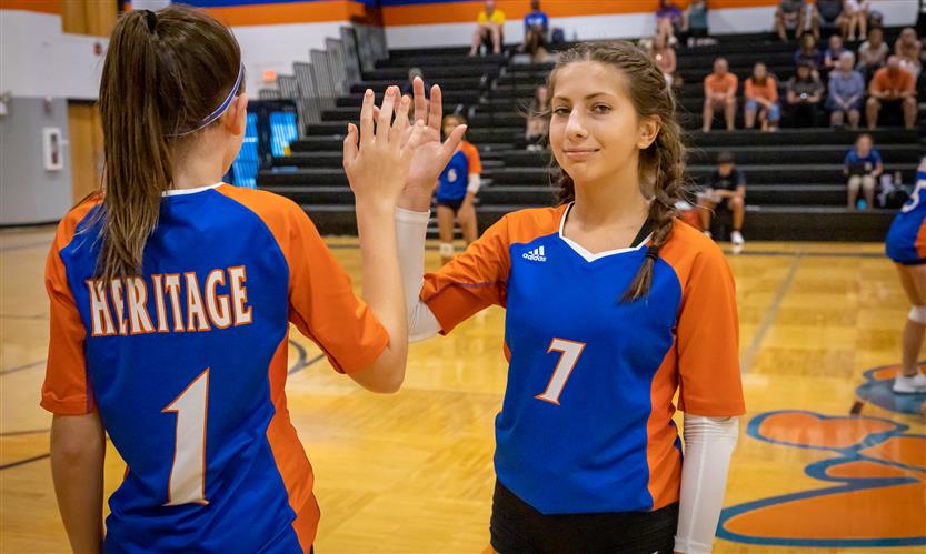 Two volleyball players prepare to substitute out